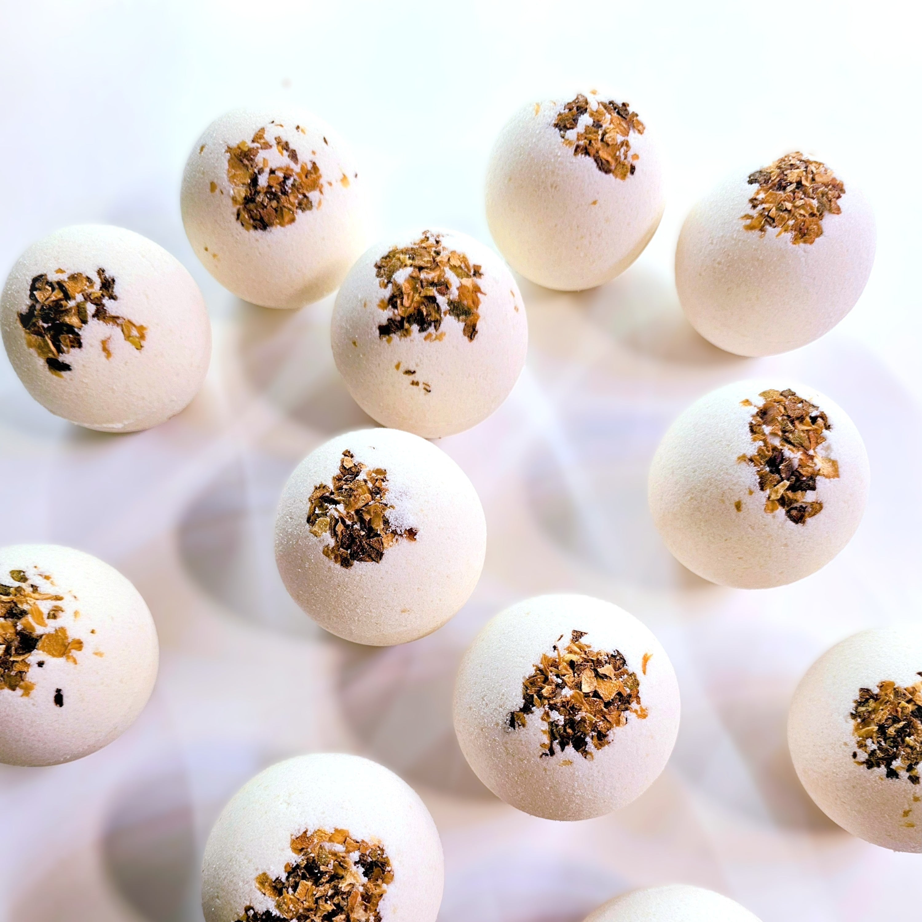 White spherical bath bombs with lime pieces arranged on a white background